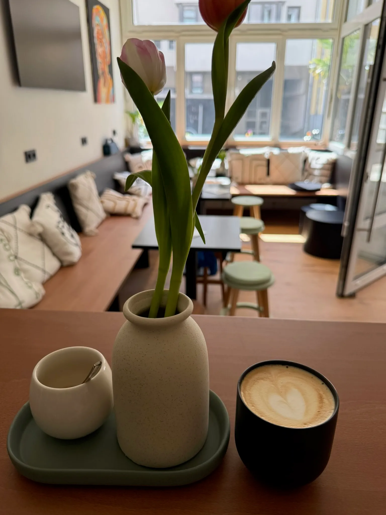 Cappuccino und Tulpe auf der Theke, im Hintergrund der Gastraum